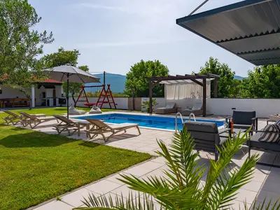 Privater, 32 m2 großer, beheizter Pool, eine Sonnenterrasse mit 6 Liegestühlen, 2 Sonnenschirmen und eine Außendusche
