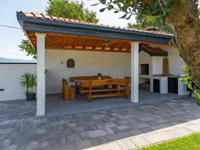 Der Außenbereich bietet einen überdachten Essbereich im Freien mit dem traditionellen Grill