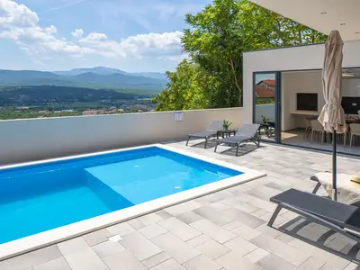 Überdachter Essbereich im Freien mit einem traditionellen Holz-/Holzkohlegrill