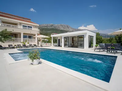he spacious sun-deck area spreads on two levels, around the pool and a few steps below on the grassplot