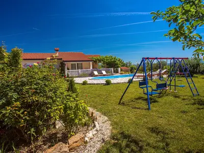 Kinderspielplatz neben dem Poolbereich, umgeben von wunderschöner Natur.