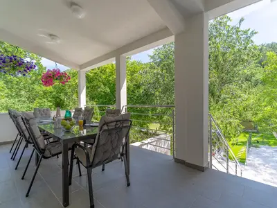 Es gibt einen Essbereich im Freien nur wenige Stufen hinauf neben dem Haupteingang des Hauses