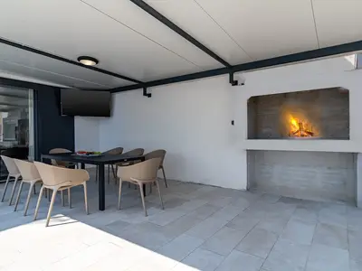 An outdoor dining area for 8, and a traditional barbecue next to it