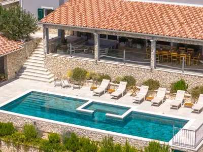 The pool is located on the lower position from the ground floor and the outdoor dining area.