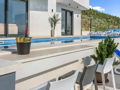 Enjoy, eine Bar mit drei Barhockern, die auch von der Innenseite des Pools aus zugänglich ist.