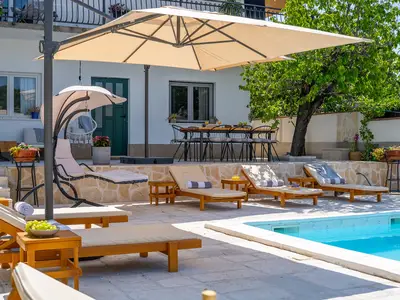 Ein komplett eingezäunter Sonnendeckbereich mit 6 Liegestühlen und zwei Lounge-Ecken