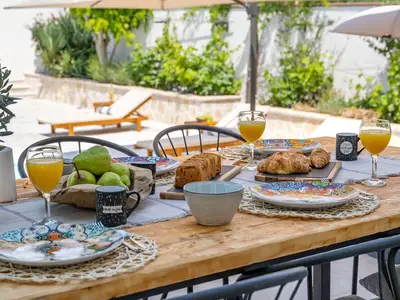 Es gibt einen traditionellen Grill, einen Ofen und einen Loungebereich mit natürlichem Schatten hinter dem Haus