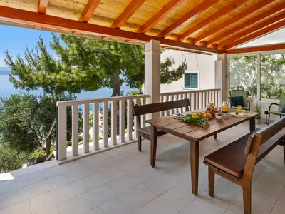 Überdachte Terrasse mit Essbereich im Freien.