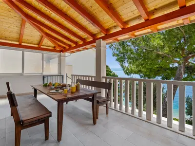 Überdachte Terrasse mit Essbereich im Freien.