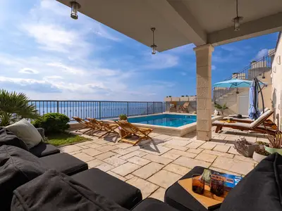 Der überdachte Teil der Terrasse bietet einen komfortablen, schattigen Wohnbereich im Freien, der sich perfekt für gesellige Stunden am Pool mit Panoramablick eignet.