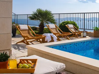 Die hölzernen Sonnenliegen am Pool sind der ideale Ort, um sich zu sonnen und ein erfrischendes Getränk mit Blick auf die Adria zu genießen.