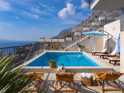 Der moderne Pool mit kristallklarem Wasser schmiegt sich an den steilen Hang und bietet eine Mischung aus Luxus und alpiner Natur