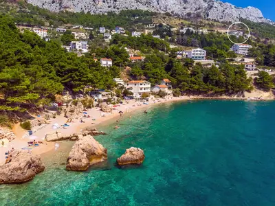 Eine Luftaufnahme zeigt die exklusive, erhöhte Lage der Villa in Mimice, oberhalb des Kiesstrandes und des klaren, blauen Meeres.