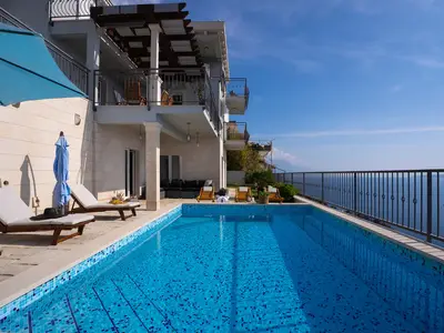 Ein privater, beheizter Pool von 25 Quadratmetern mit Gegenstromanlage, der mit blauen Mosaikfliesen ausgekleidet ist, unterstreicht die Geräumigkeit der Terrasse und den freien Blick auf die Adria.