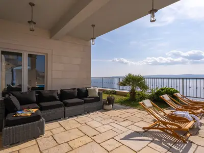 Der Außenwohnbereich ist nahtlos mit der Sonnenterrasse verbunden, sodass die Gäste wählen können, ob sie im Schatten entspannen oder die Sonne genießen möchten.