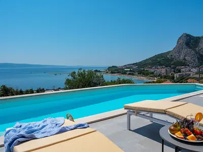 a sun deck area with 6 decks chairs overviewing town Omiš, sea and mountains