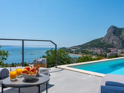 a sun deck area with 6 decks chairs overviewing town Omiš, sea and mountains
