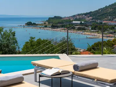 a sun deck area with 6 decks chairs overviewing town Omiš, sea and mountains