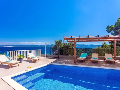 Poolbereich mit 6 Liegestühlen und Gartenmöbeln, Blick auf das offene Meer und die Insel