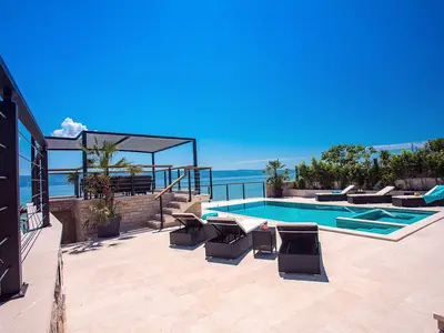Poolbereich mit Sonnendeckbereich, Außendusche, Sitzecke und Ausgang zum Strand