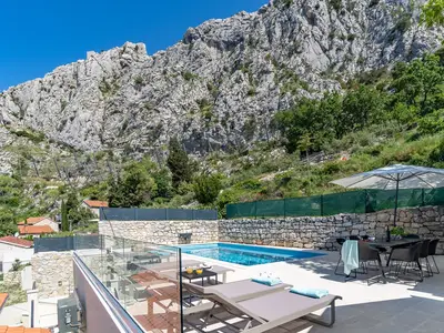 Ein Sonnendeckbereich mit 6 Liegestühlen, zusätzlich 6 Terrassenstühlen und dem Esstisch mit Sonnenschirmen