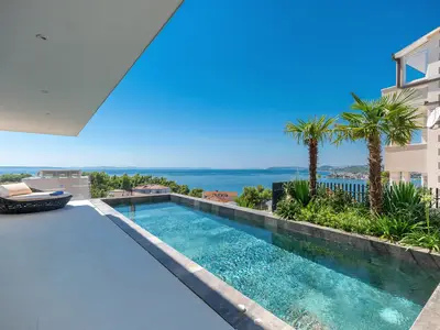 Der Außenbereich bietet ein Sonnendeck mit Meerblick, einen privaten und beheizten Pool von 25,2 m2 (9 m x 2,8 m) mit Hydromassage und ein vollautomatisches Salzelektrolysesystem