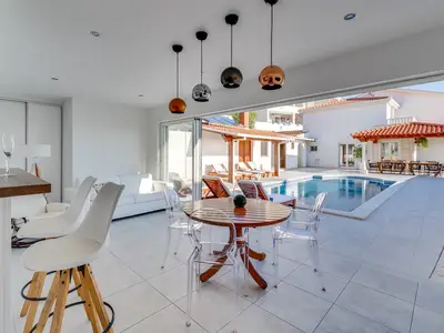 Modern summer kitchen and lounge area next to the pool