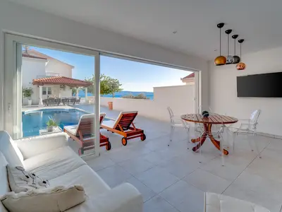 Modern summer kitchen and lounge area next to the pool