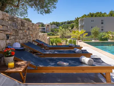 There is a sun deck area with 6 deck chairs, an outdoor shower, a covered outdoor dining area 
