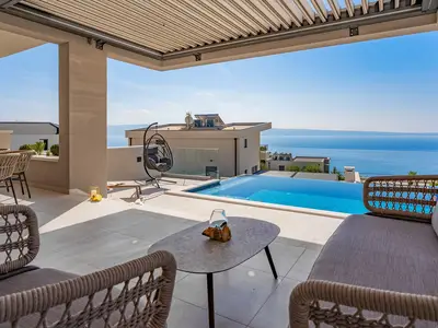 Lounge-Ecke mit offenem Meerblick und Blick auf die Villen