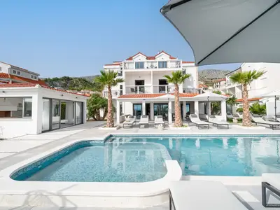 Der Außenbereich bietet einen privaten beheizten Swimmingpool von 54 m2 (12 m x 4,5 m) mit Sonnenliegen auf der Sonnenterrasse mit 14 Sonnenliegen und einer Sommerküche.