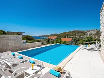 Der Außenbereich bietet ein Sonnendeck mit Meerblick, einen privaten und beheizten Pool mit Hydromassage und ein vollautomatisches Salzelektrolysesystem
