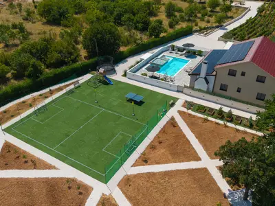 Spielbereich mit einem 21 x 18 m großen Fußballfeld mit weichem Kunstrasen und einem leicht aufzubauenden Badmintonnetz