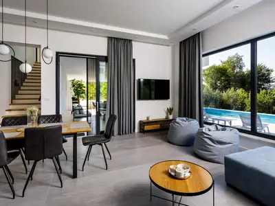 Das Erdgeschoss bietet ein geräumiges Wohnzimmer mit einem Flachbild-TV mit Netflix und IPTV, einer Klimaanlage, kostenlosem WLAN, einem bequemen Sofa und zwei Lazy Bags mit Glaswänden zum Poolbereich.
