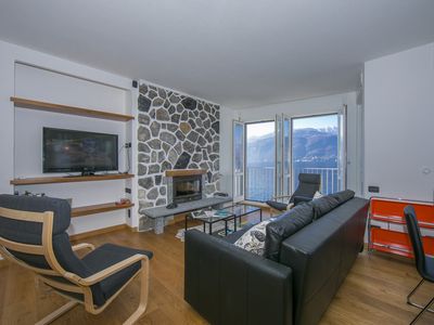 Wohnzimmer mit Fernseher und Ausblick über den See