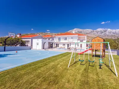 Ein Spielplatz für jüngere Mitglieder Ihrer Gruppe und bietet eine Schaukel, eine Rutsche und ein Holzhaus