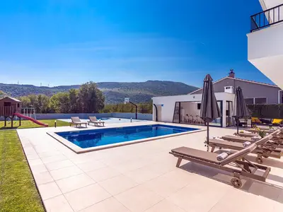 Der geräumige Außenbereich bietet einen privaten und beheizten 9 x 4,5 m großen Pool