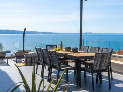 Überdachter Esstisch im Freien mit Grill und Lounge-Ecke