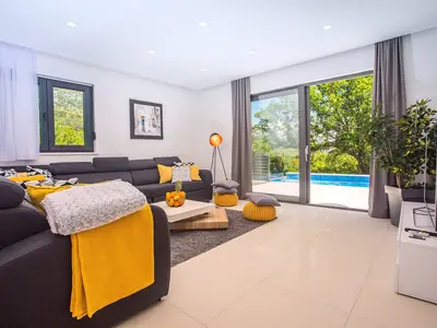 moderner Wohn - und Essbereich mit Blick auf den Pool-bereich