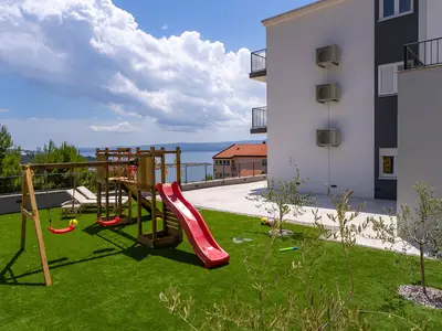 Der große Sonnendeckbereich verfügt über einen Kunstrasenplatz, ein hölzernes Kinderhaus mit Rutsche und einige Extras für Ihre jüngsten Gäste
