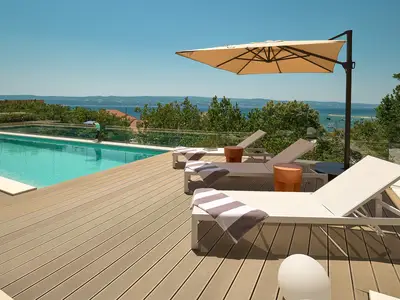 Ein Sonnendeck mit 4 Liegestühlen und einer eingebauten Sonnendeckbank mit Kissen, einer Außendusche