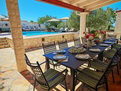 Der überdachte Essbereich im Freien bietet Platz für 14 Gäste für Mahlzeiten, perfekt gelegen neben dem Pool..