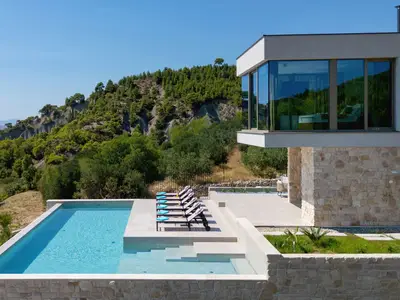 Moderner Außenbereich der Villa mit privatem Pool und einem flachen Bereich mit Hydromassage-Funktionen.