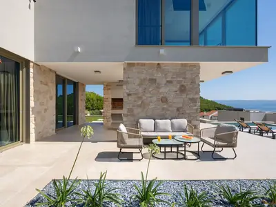 Der Außenbereich verfügt über eine komfortable Lounge-Ecke, die einen entspannenden Ort neben dem privaten Pool bietet.