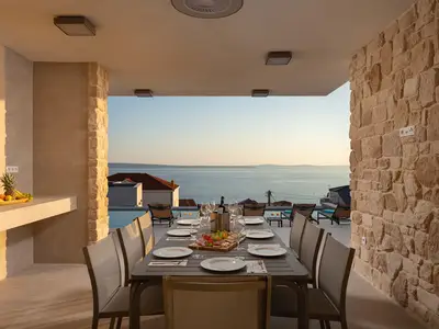 Genießen Sie Mahlzeiten im Freien (Alfresco Dining) im überdachten Außenbereich mit Grill, der eine herrliche Aussicht auf das Meer und die Umgebung bietet.