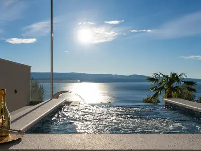 Der private, beheizte Infinity-Pool verfügt über einen integrierten Hydromassagebereich mit Wasserfall, ideal für entspannende Momente.