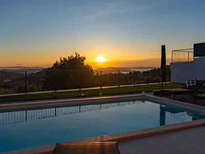 Der 32 qm große Pool spiegelt den goldenen Sonnenuntergang wider und bietet eine spektakuläre Aussicht auf das Meer und die Landschaft.