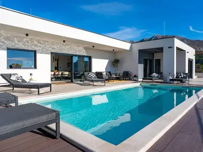 Modernes Villendesign mit privatem Pool und Sonnenterrasse mit sechs Liegen.
