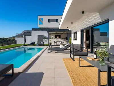 Der nahtlose Übergang vom Essbereich im Innenraum zur Sonnenterrasse bietet eine atemberaubende Aussicht auf Split.