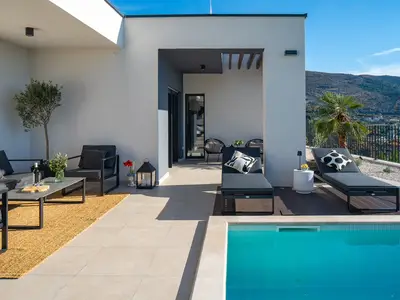 Außenbereich mit der gemütlichen Lounge-Ecke und Zugang zum Pool, ideal für ruhige Auszeiten.